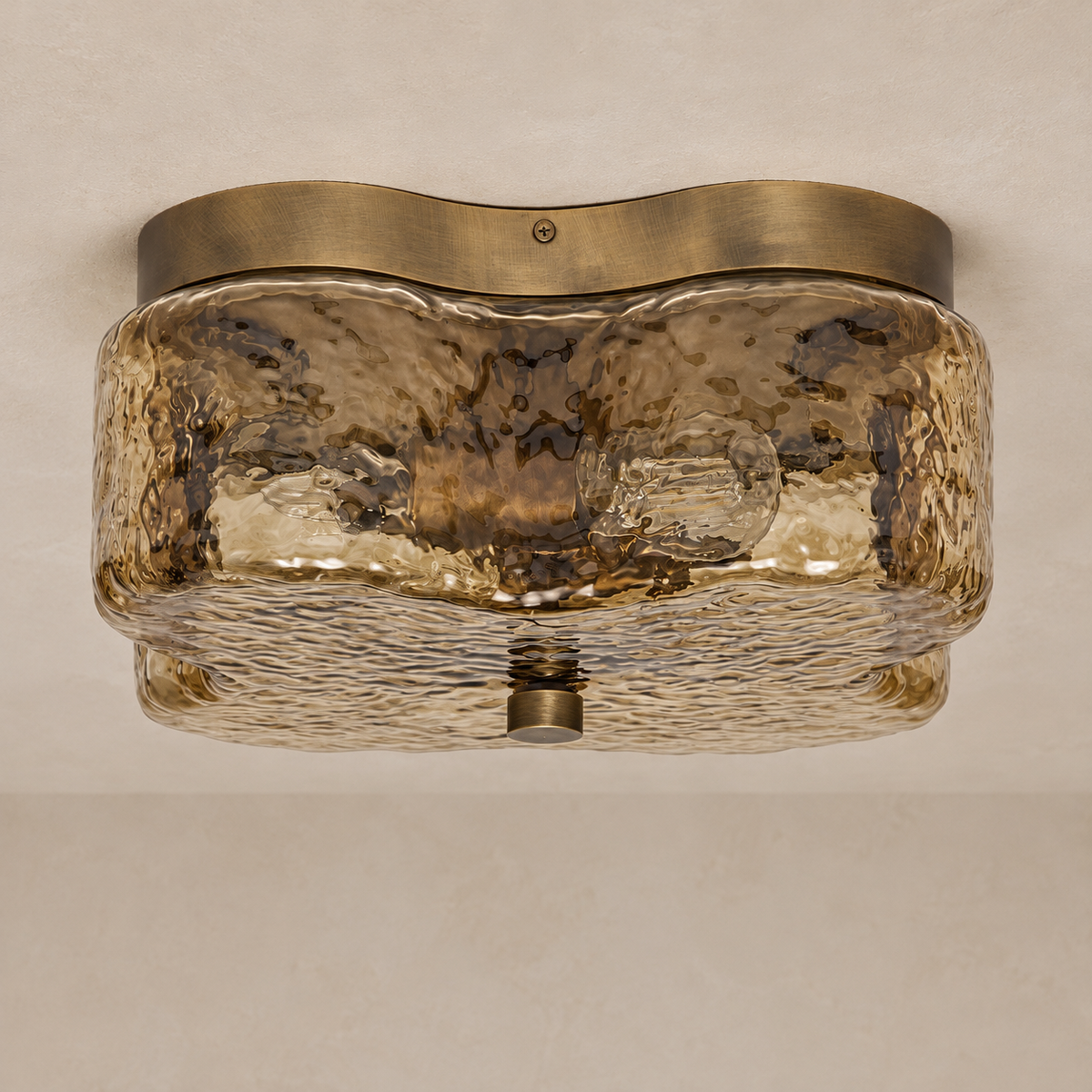 Amber quatrefoil glass flush mount switched off, with its waved brass ceiling plate.