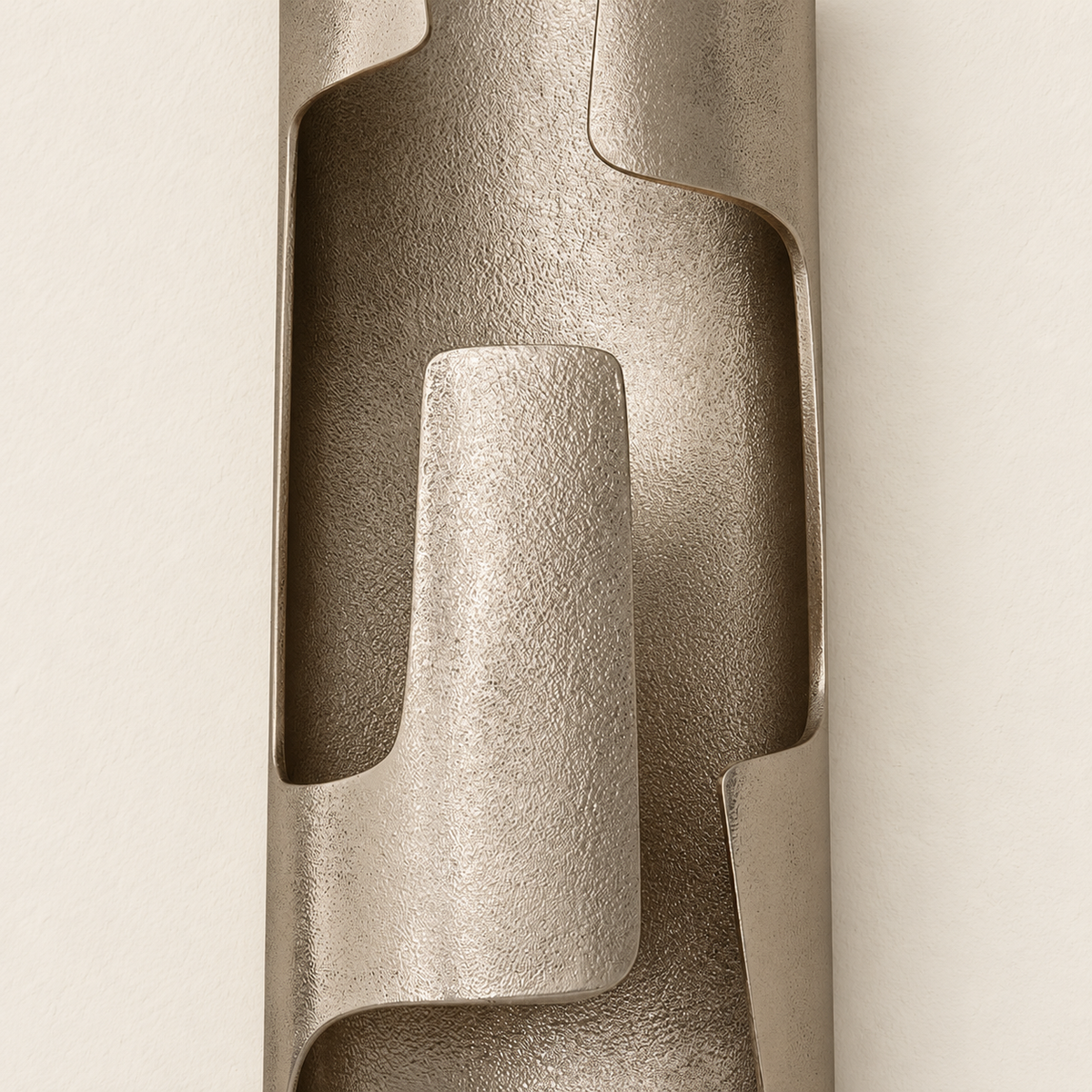 Close-up of the sconce’s textured champagne bronze finish and overlapping curved metal edges.