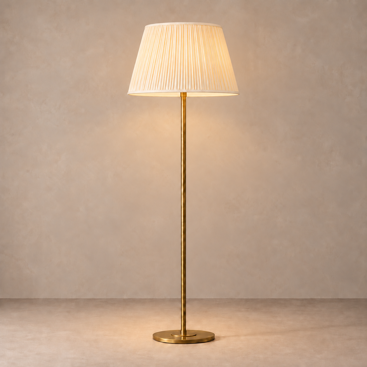 Brushed Brass Floor Lamp with cream fine pleated shade, illuminated in natural daylight.