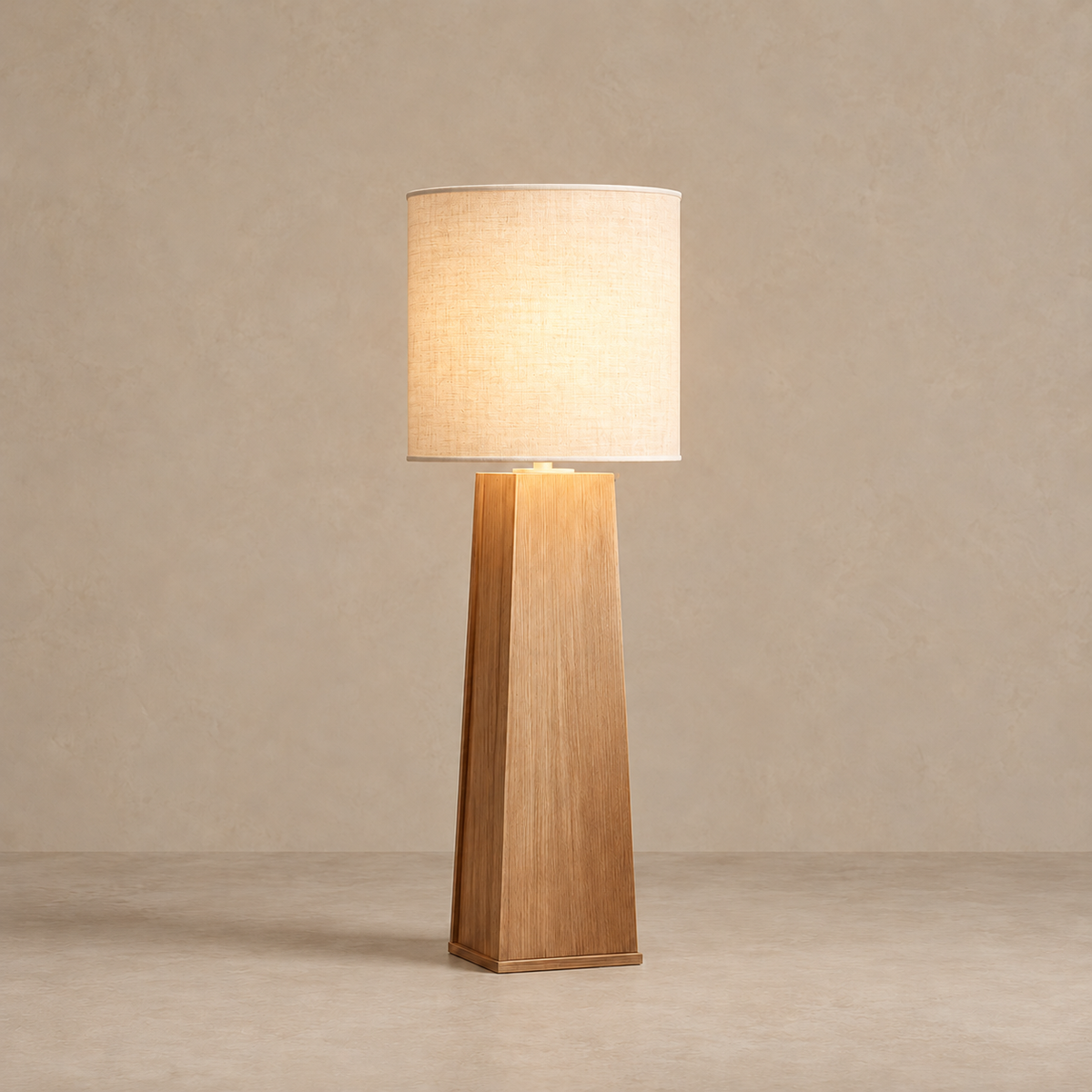 CLSTUD059 floor lamp with its cylindrical linen shade illuminated.
