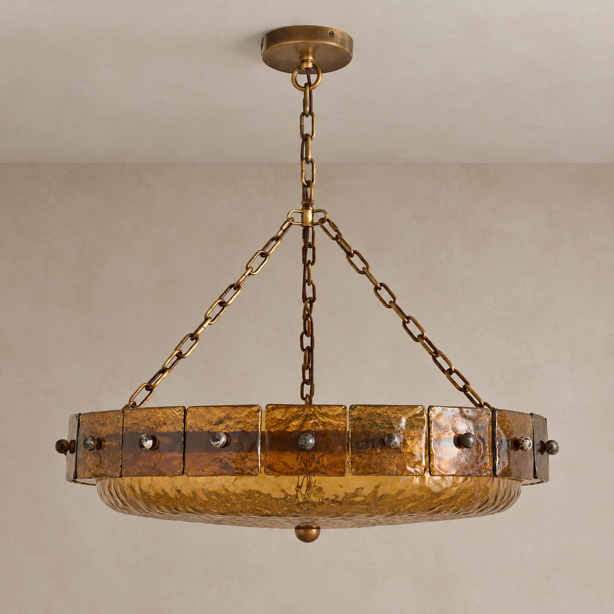 Amber glass bowl chandelier switched off, with its brass canopy and three-chain suspension.