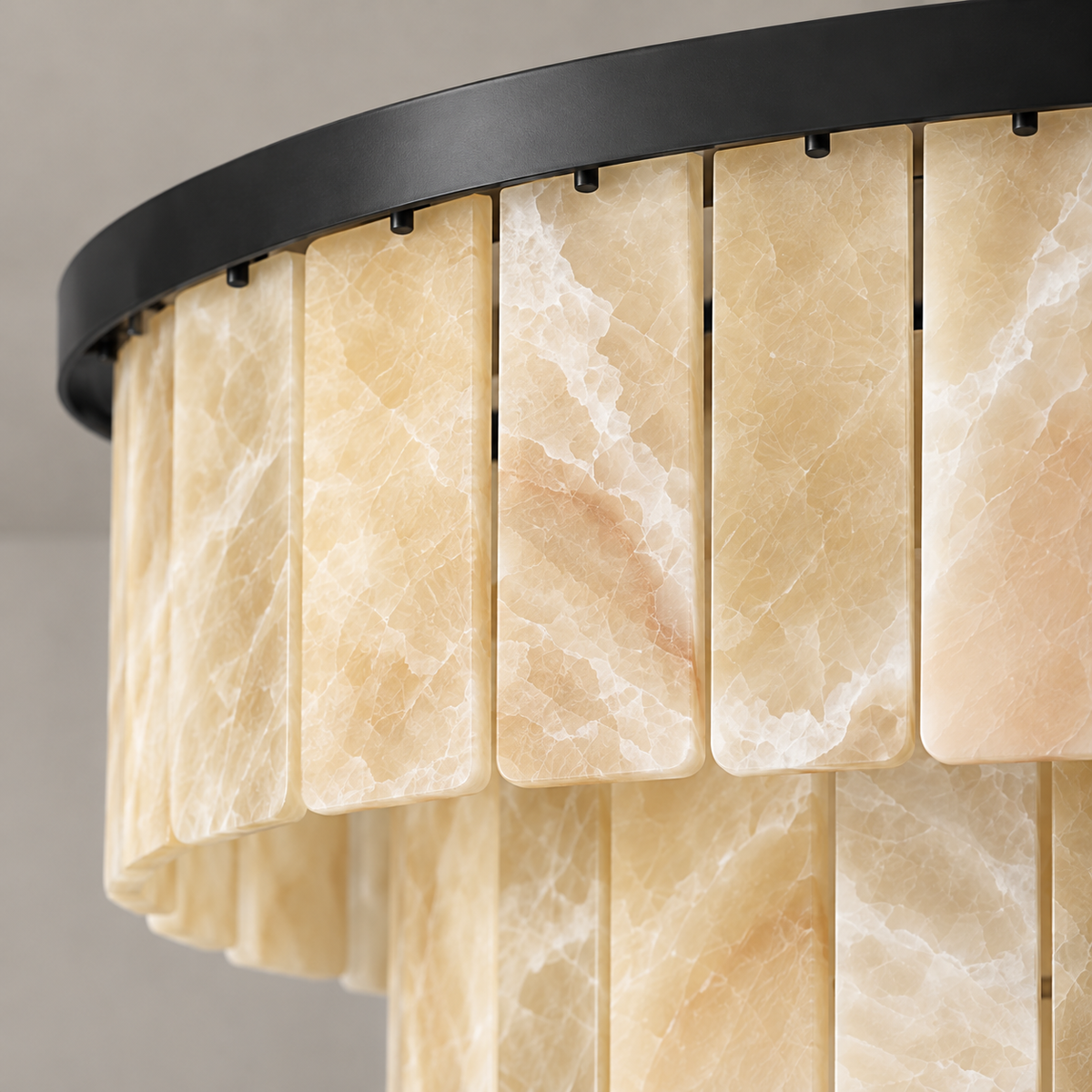 Close view of honey onyx panels and black rim on the tiered chandelier.