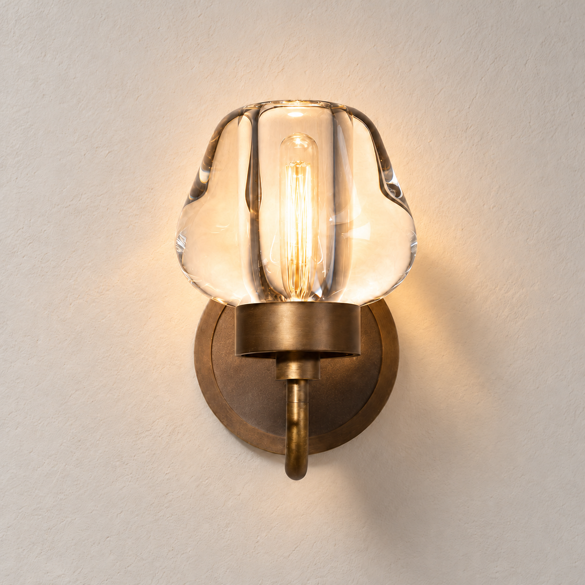 Front view of the brass and hand-formed crystal wall sconce, illuminated.