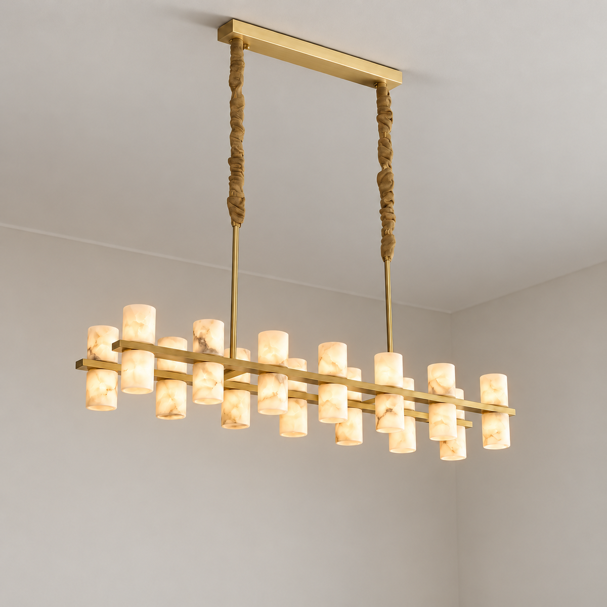 Filari brass chandelier illuminated through naturally clouded alabaster cylinders.