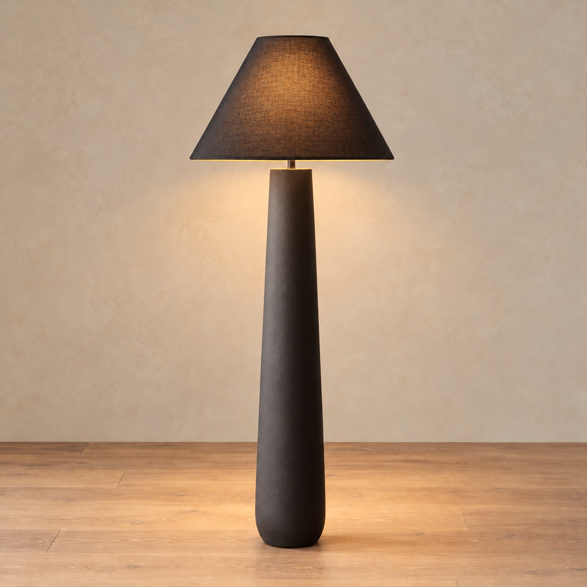 Black Fungo Bianco floor lamp lit, with warm light passing through the dark fabric shade.