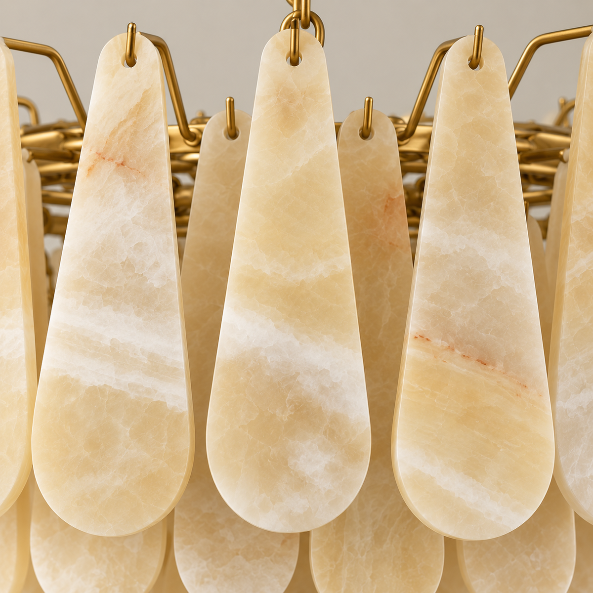 Honey onyx teardrops, brass hooks and chandelier frame in close-up.