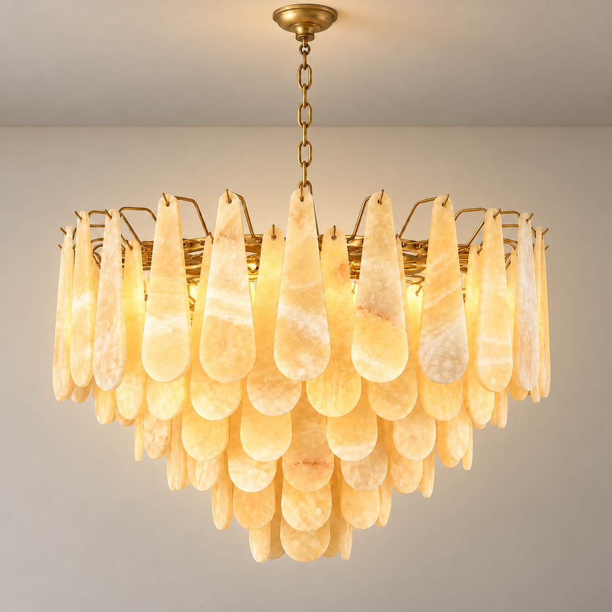 80 cm Goccia honey onyx chandelier with six tiers and brass suspension, illuminated.