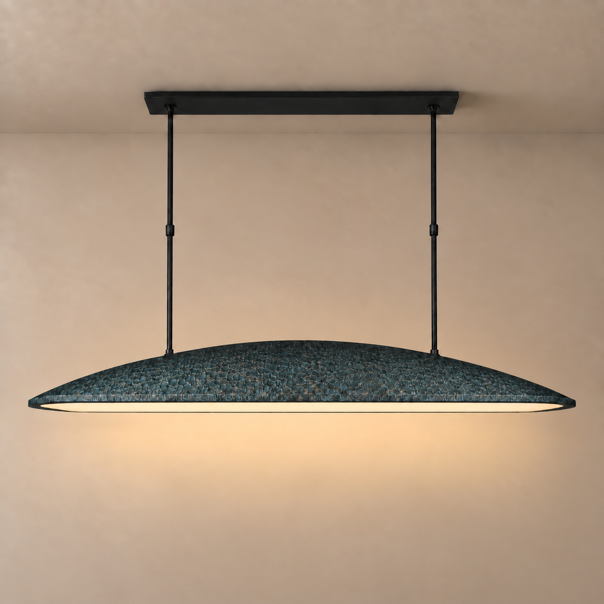 Green linear pendant light lit, light falling straight down from the oval shade