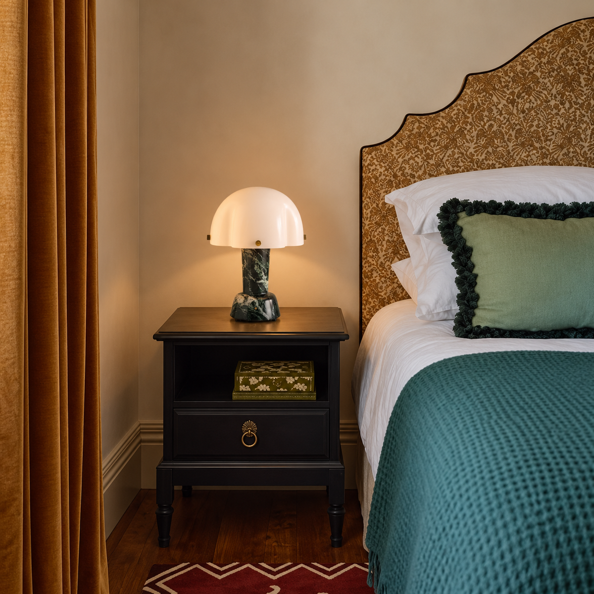 Green Marble Table Lamp on a black bedside table beside teal bedding.
