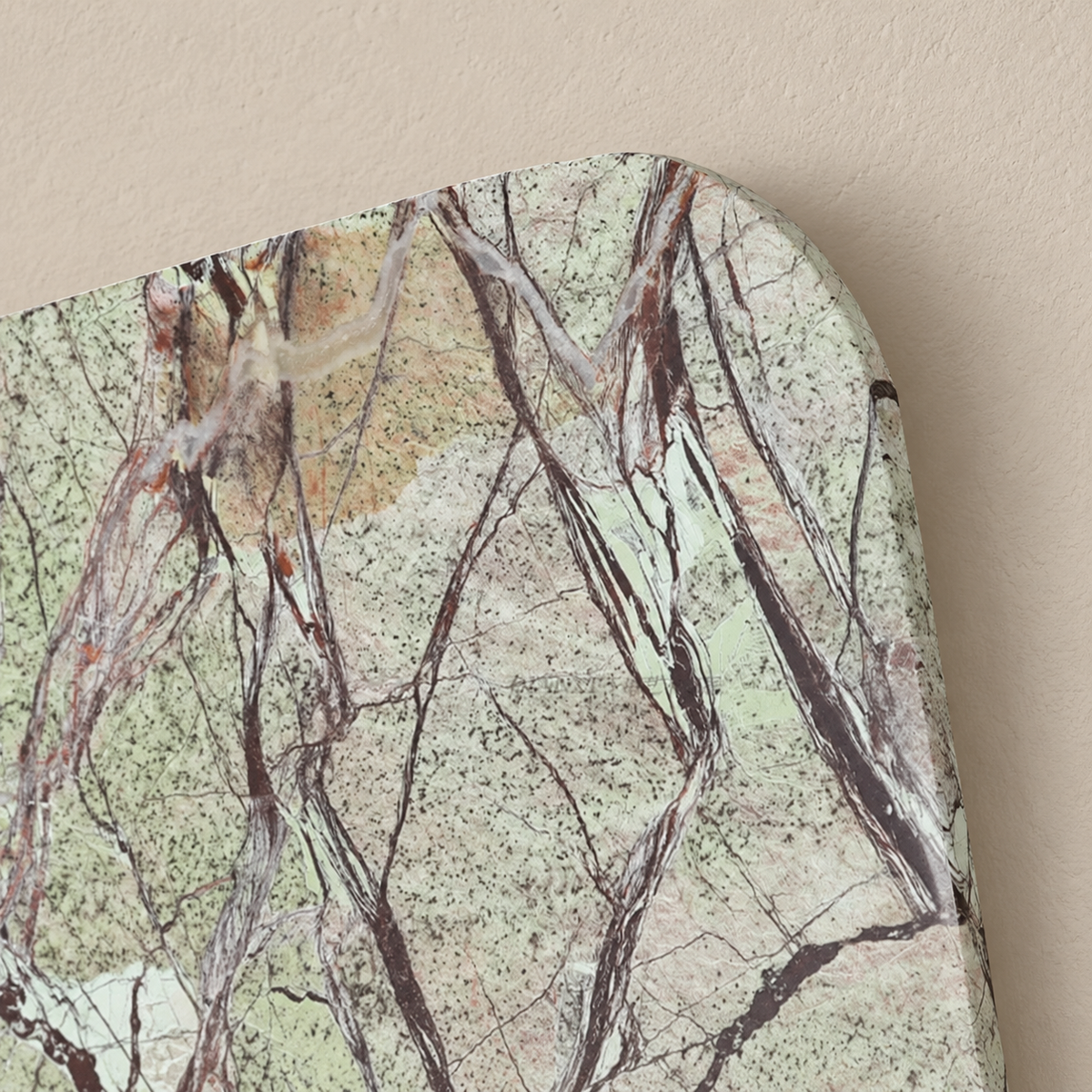 Close-up of the green marble panel’s rounded corner and original dark veining.