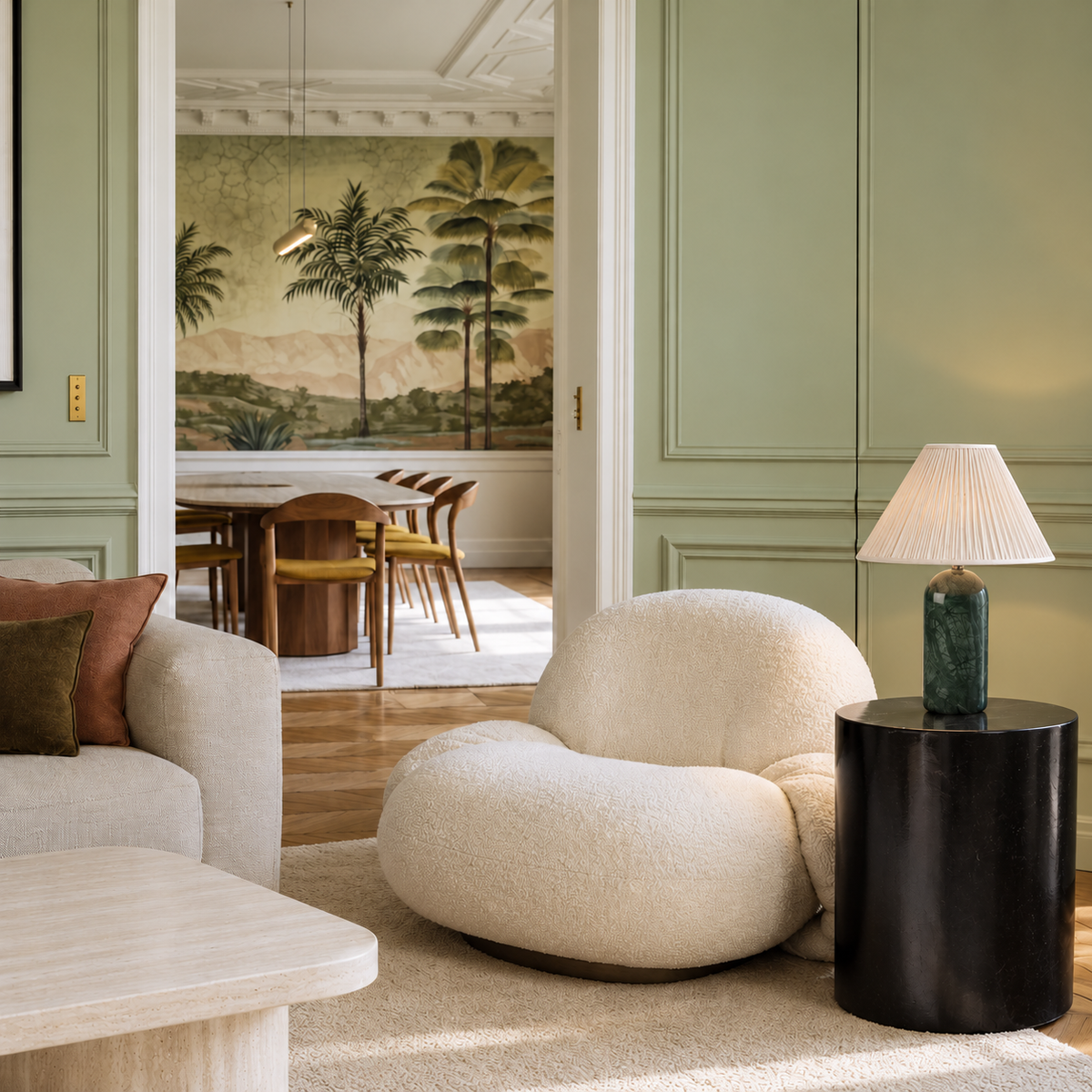 Green marble table lamp with a pleated shade on a black side table beside a cream armchair.