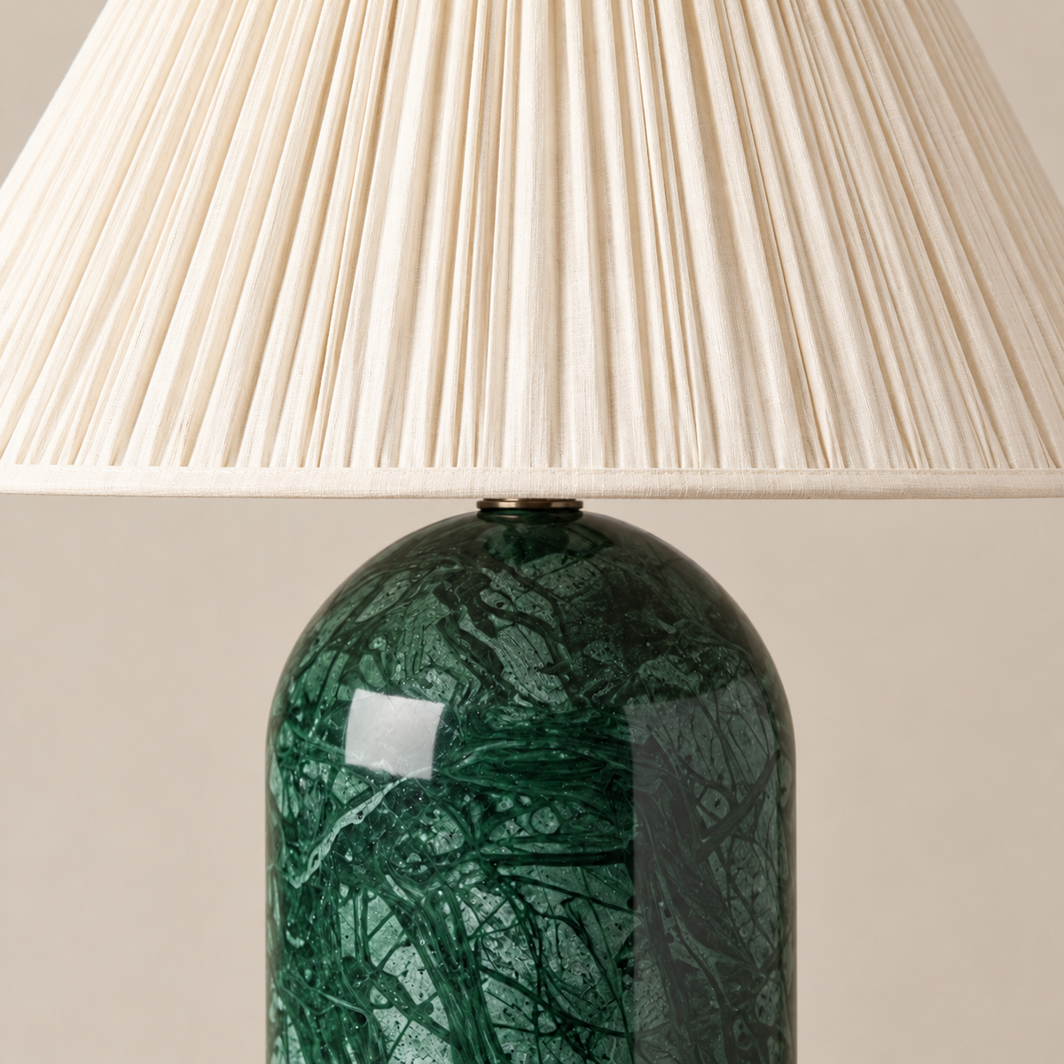 Fine pleats and cream edging above the green marble table lamp base.