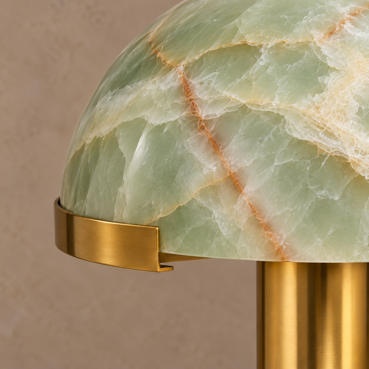 Close-up of green stone dome edge and curved brass retaining clip on the CL025MBZ-GO.