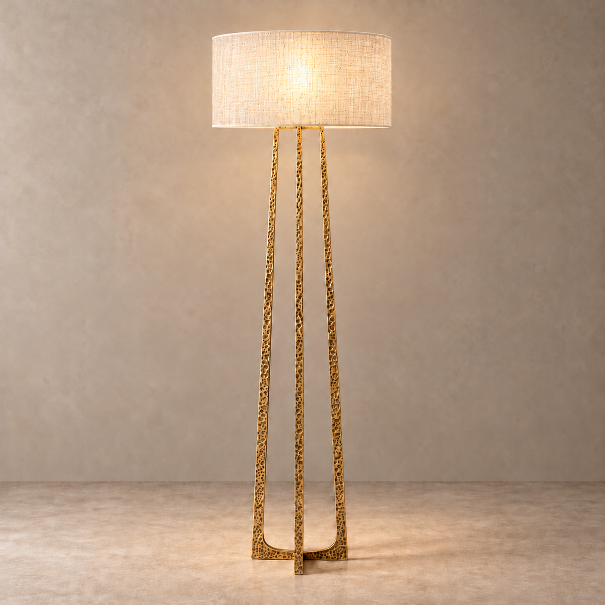 hammered brass floor lamp lit through a single-layer silk abaca drum shade