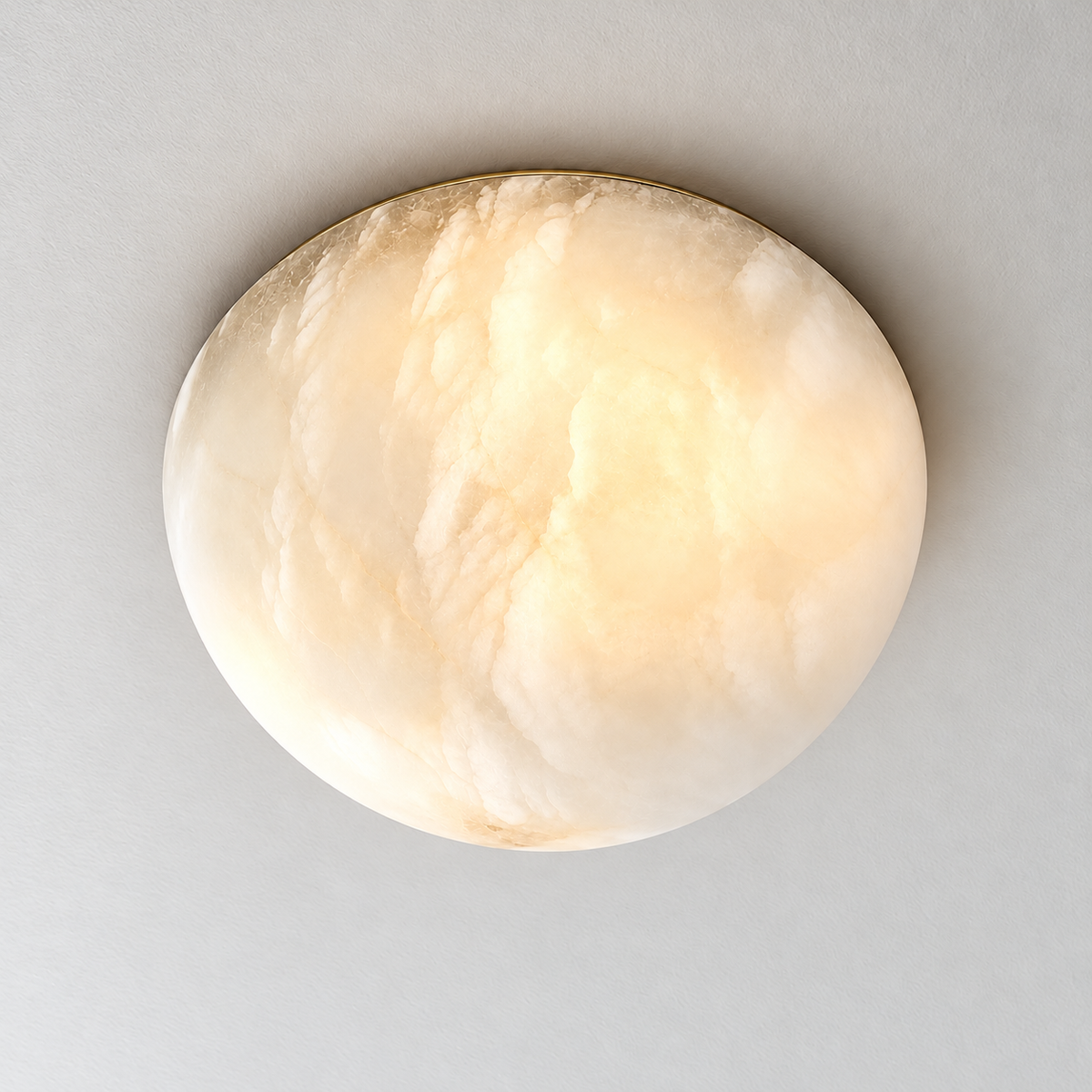 Honed alabaster dome illuminated, showing the same natural cloudy mineral bands.