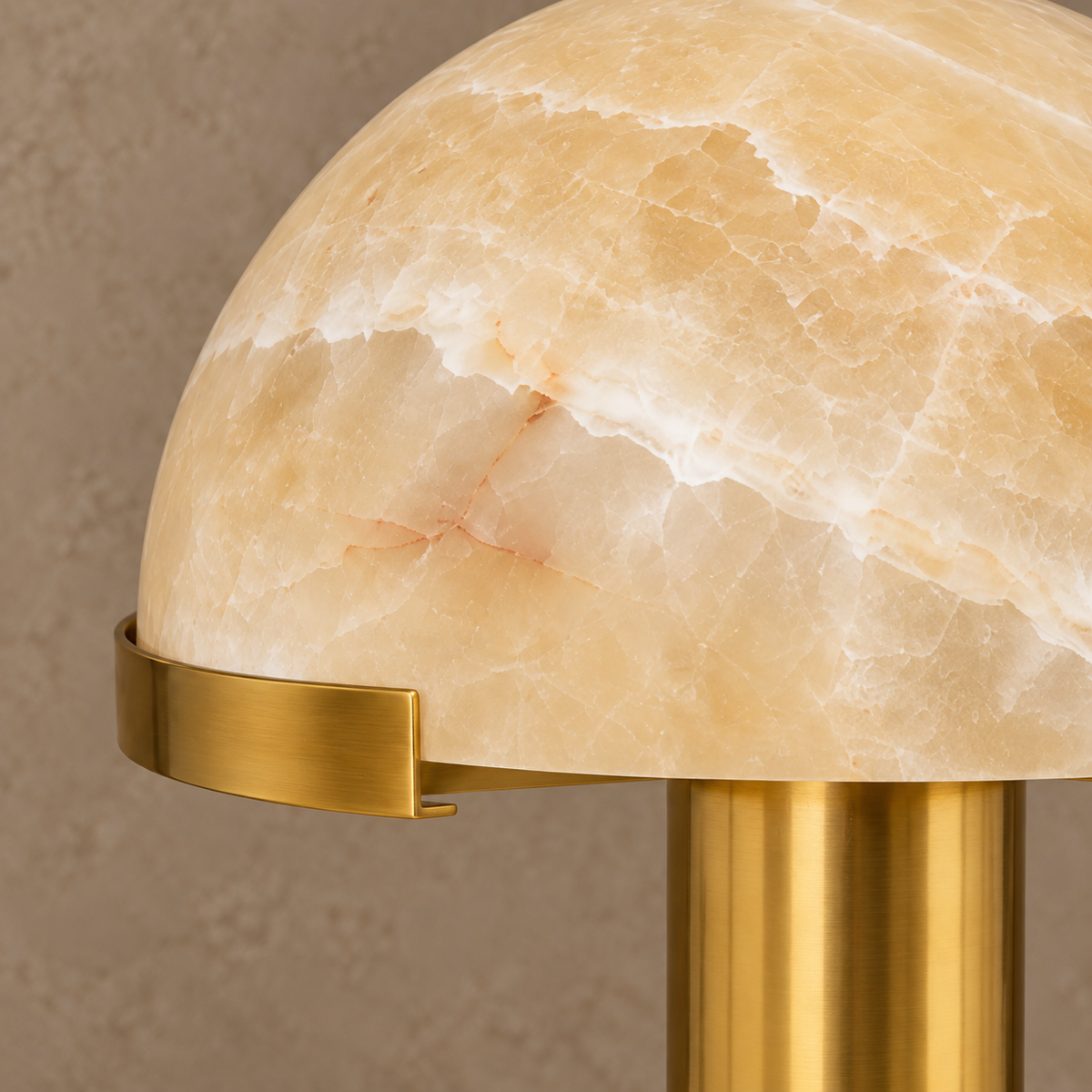 Close-up of honey stone dome edge and curved brass retaining clip on the CL025MBZ-HO.