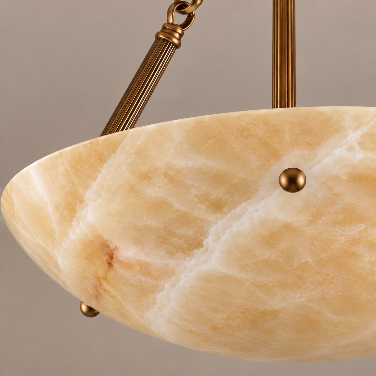 Honey onyx bowl rim and decorative brass support in close-up.