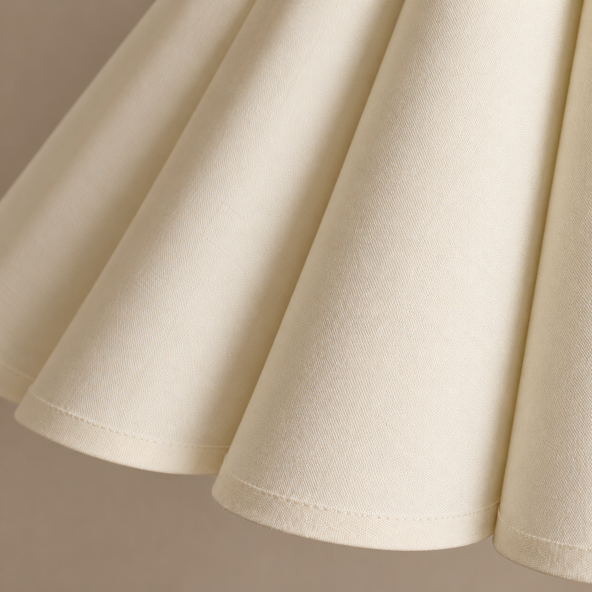 Close view of the Japandi lamp's rounded fabric pleats, fine weave and stitched lower edge.