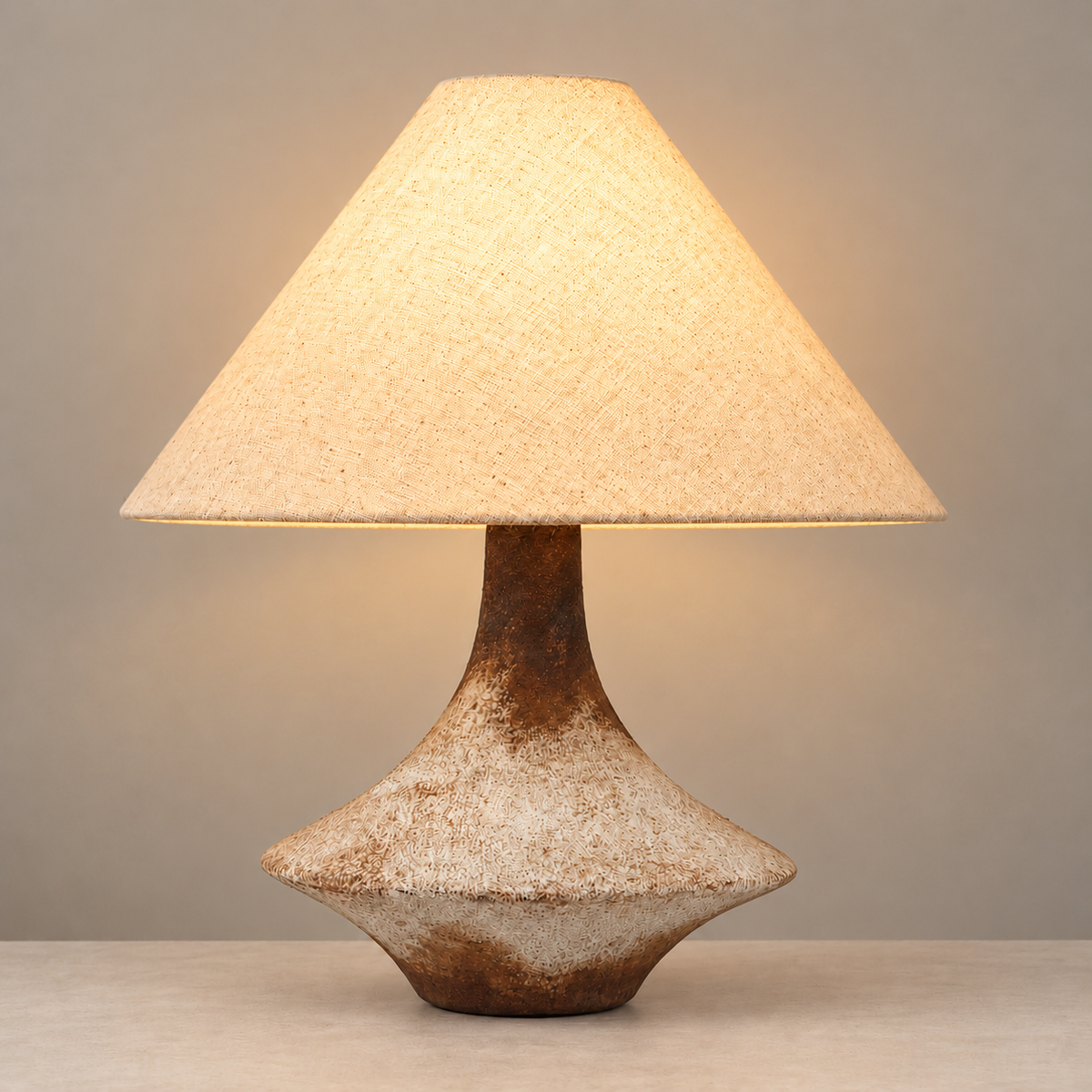 La Rustica Table Lamp, illuminated, on a neutral beige background.