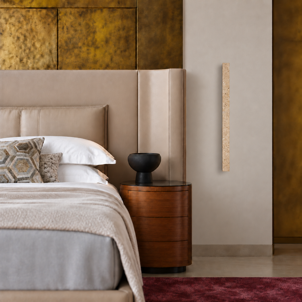 La Tavola travertine wall light shown straight on beside a walnut bedside cabinet, with its rear wooden mount concealed behind the stone.