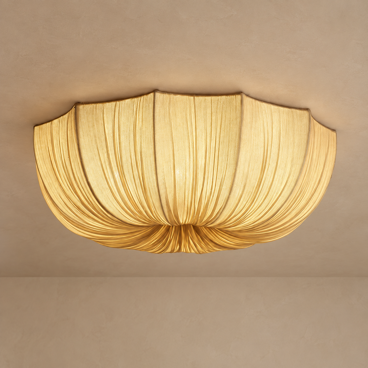 Draped linen flush mount ceiling light lit, the linen glowing warm cream