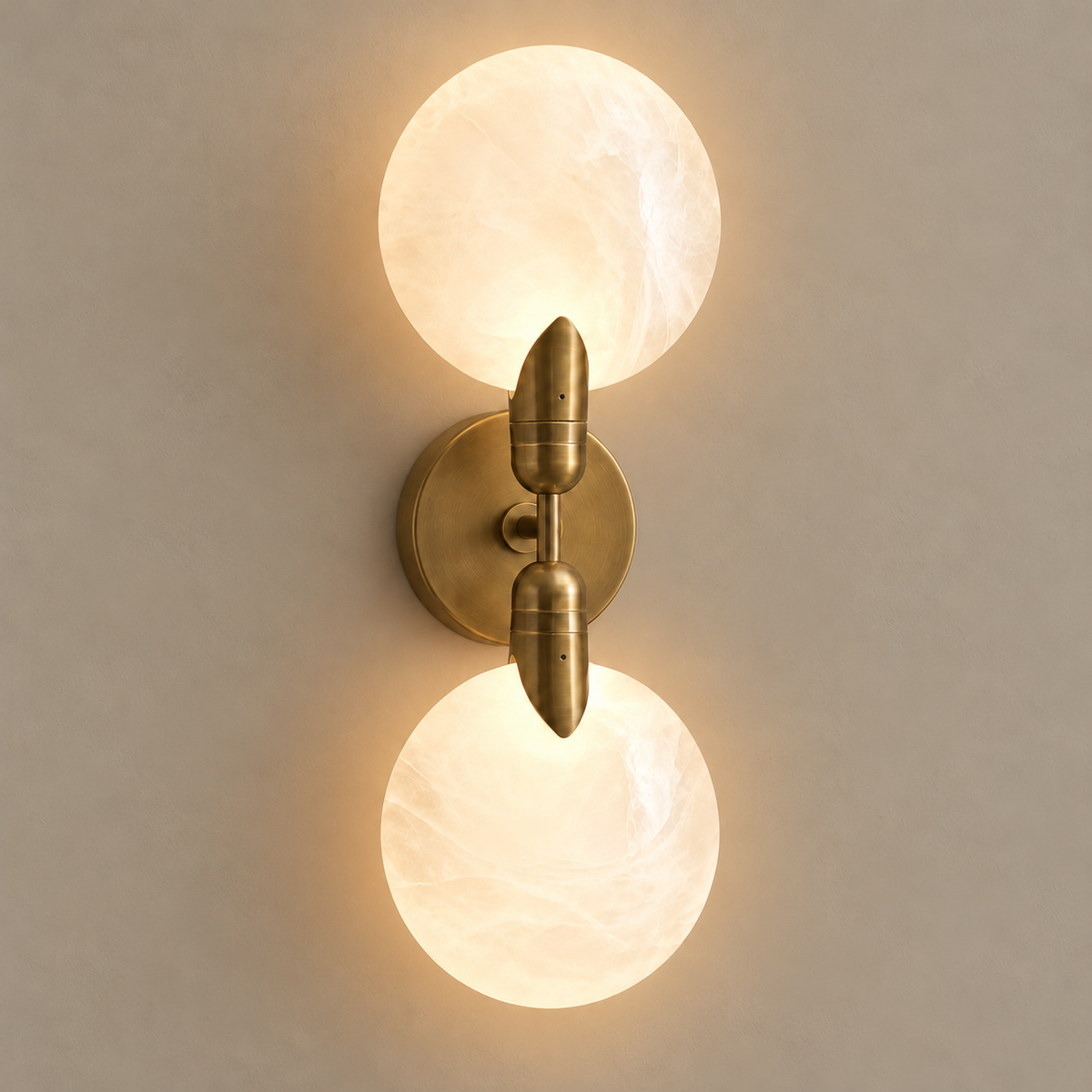Luna Doppia brass and white glass wall sconce, illuminated on a stone-beige wall