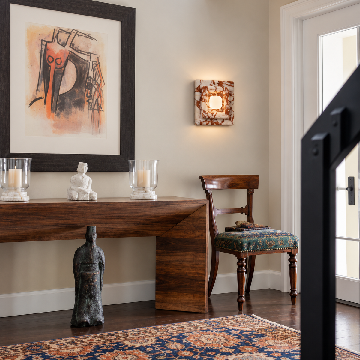 Red marble square wall sconce installed beside a walnut entryway console.