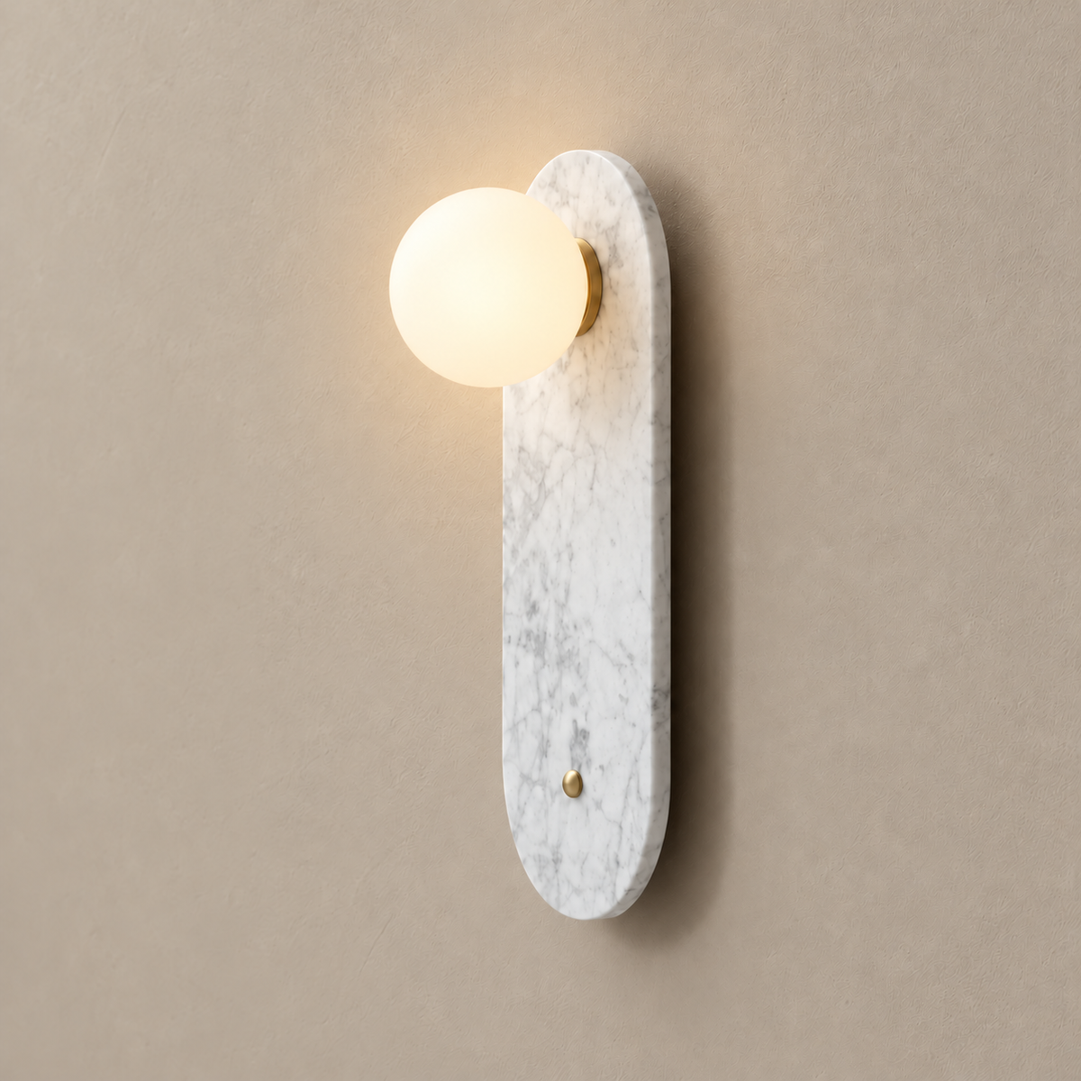 White marble wall sconce with its frosted glass globe illuminated.