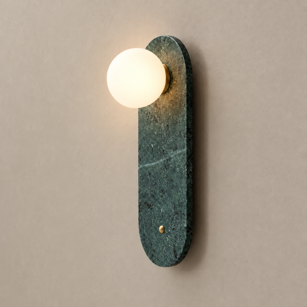 Green marble wall sconce with its frosted glass globe illuminated.