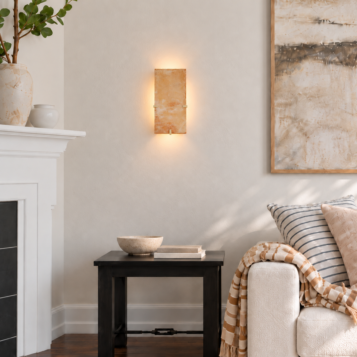 Backlit onyx wall sconce above a side table beside a cream sofa in a naturally lit living room.