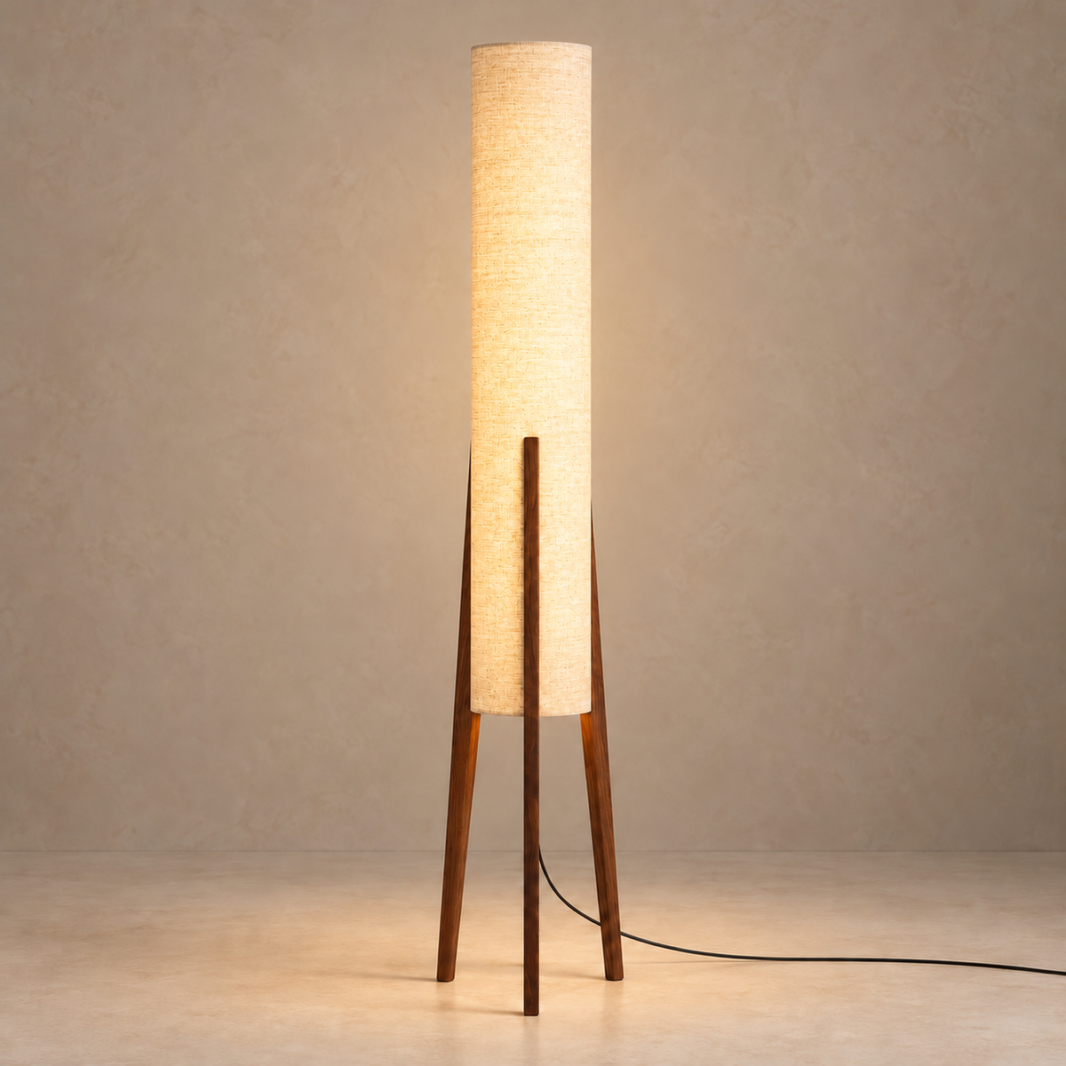 Piloni Walnut floor lamp with its cylindrical linen shade illuminated.