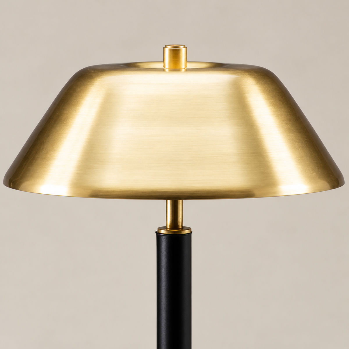Close view of the brass shade and black stem connection.