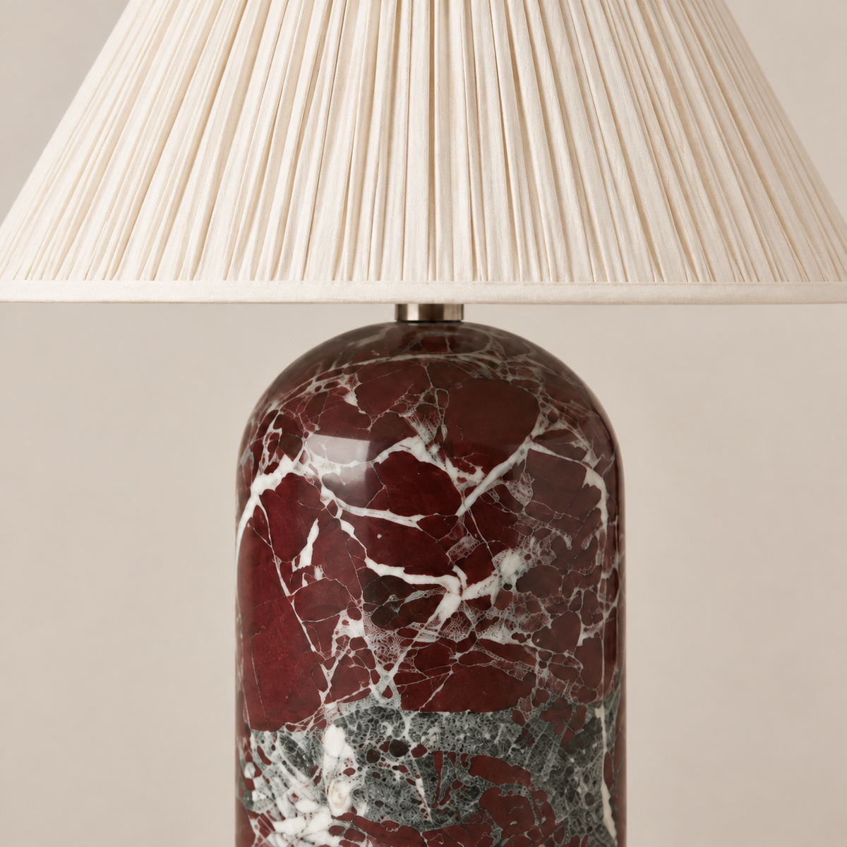 Fine pleats and cream edging above the red marble table lamp base.