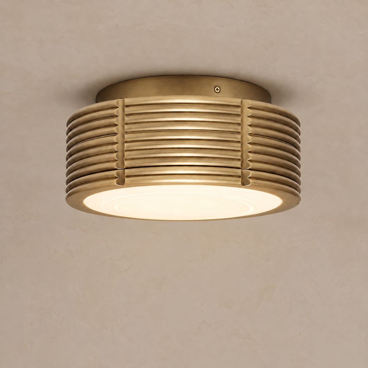 CLBND033 brass drum ceiling light illuminated through its frosted glass diffuser.