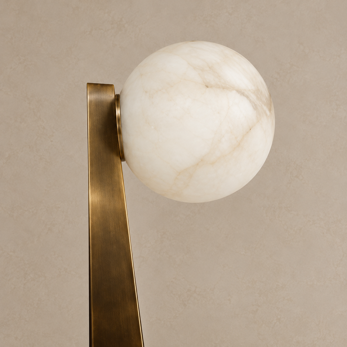Close-up of cloudy alabaster and its side attachment to the patinated-brass support.