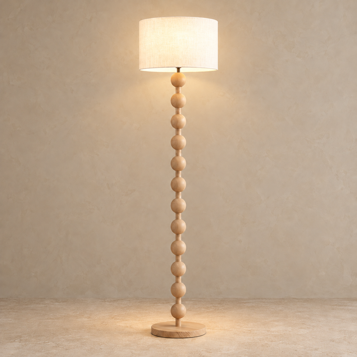 Sirmione floor lamp in natural Log finish with its linen shade illuminated.