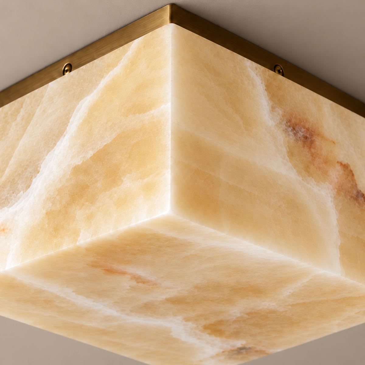 Square honey onyx corner, mineral bands and brass ceiling plate in close-up.