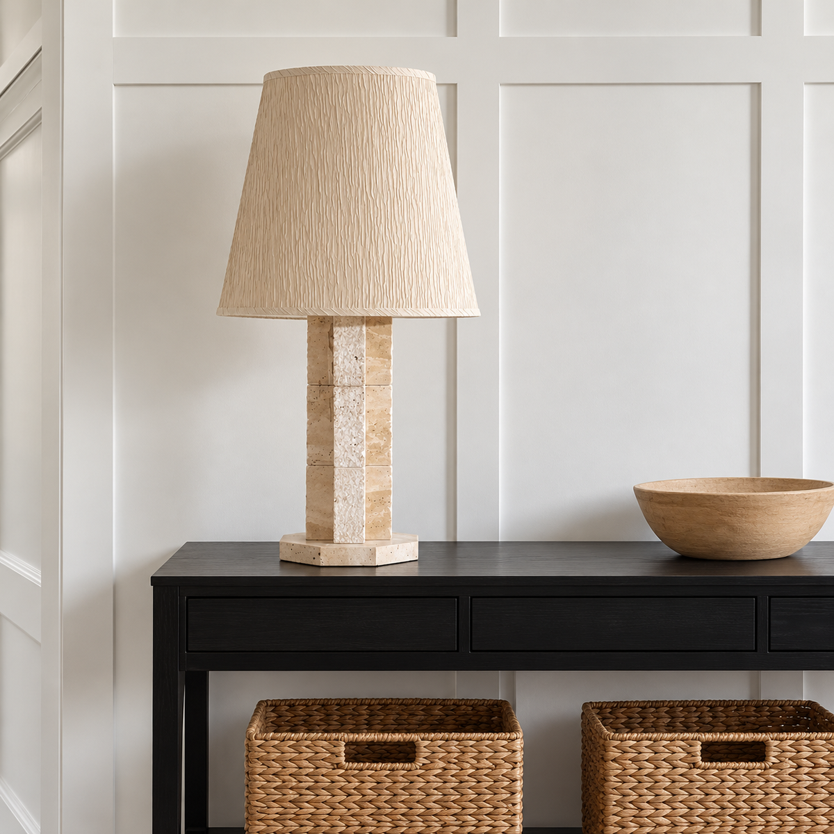 Travertine table lamp on a black entryway console.