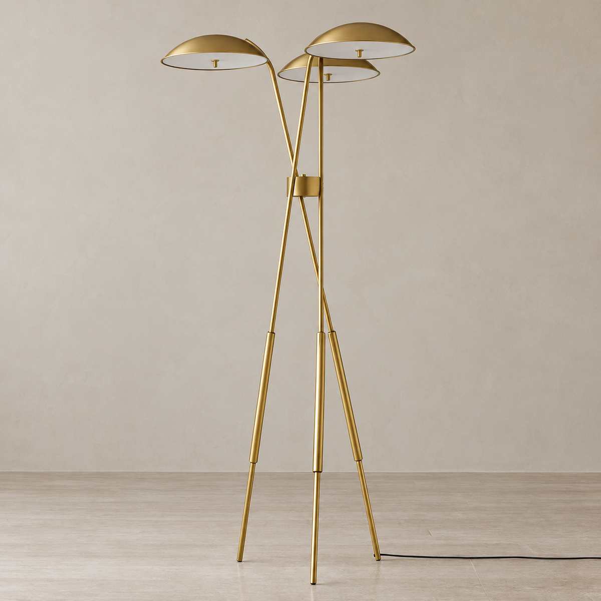 Trilume floor lamp switched off, with three shallow brass shades and slender tripod legs.