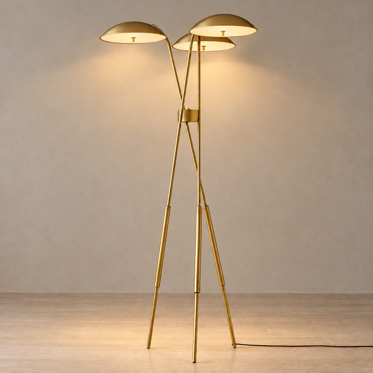 Trilume floor lamp illuminated, with three softly glowing shades on its brass tripod.
