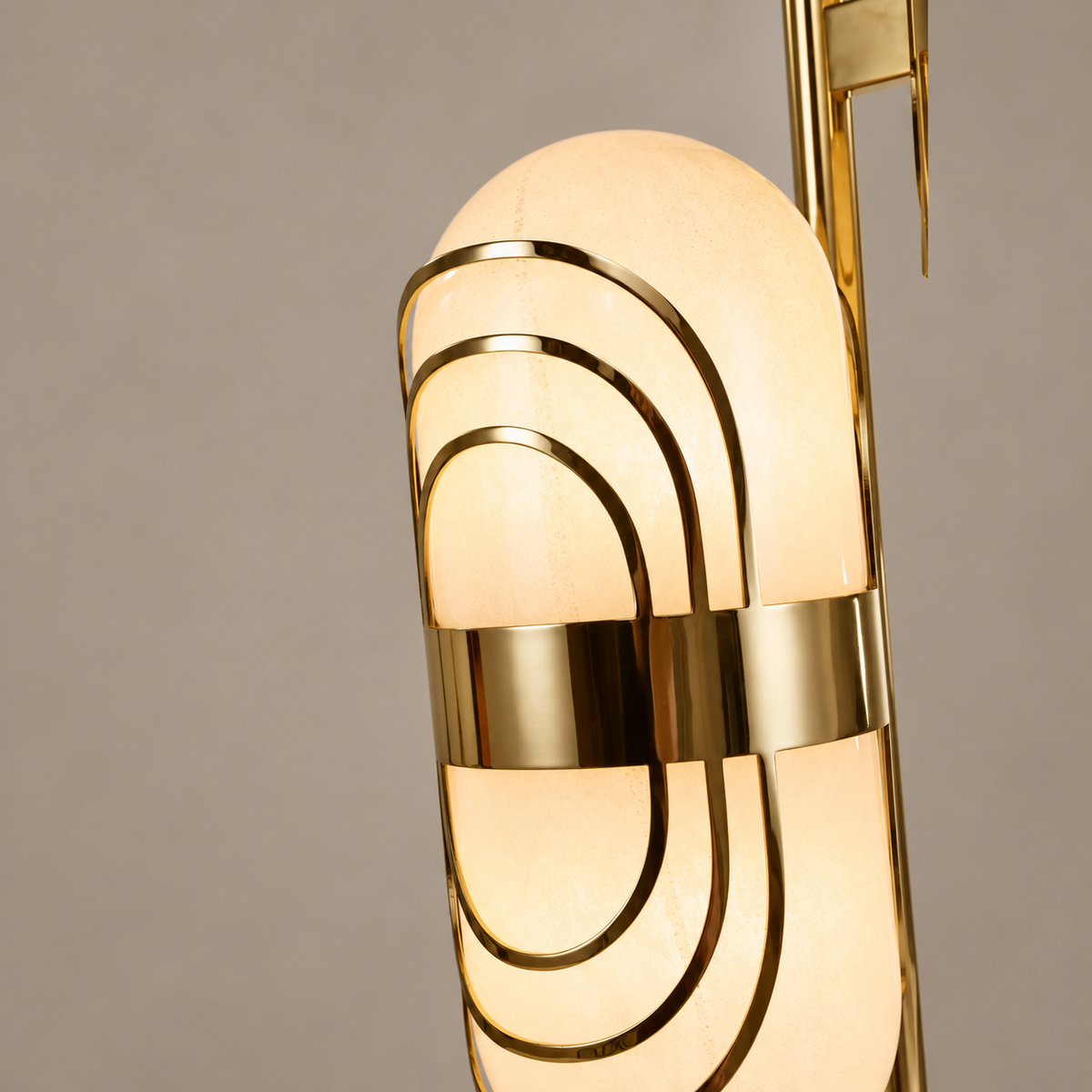 Close-up of illuminated opal glass with three brass oval strips and a polished central band.