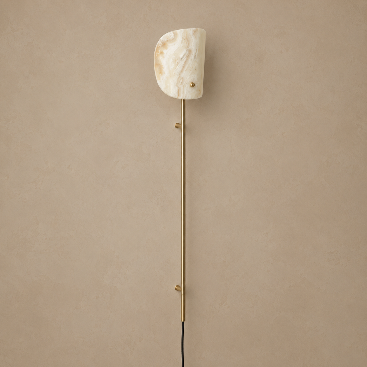 Valen onyx and brass wall rail lamp, unlit on a stone-beige wall