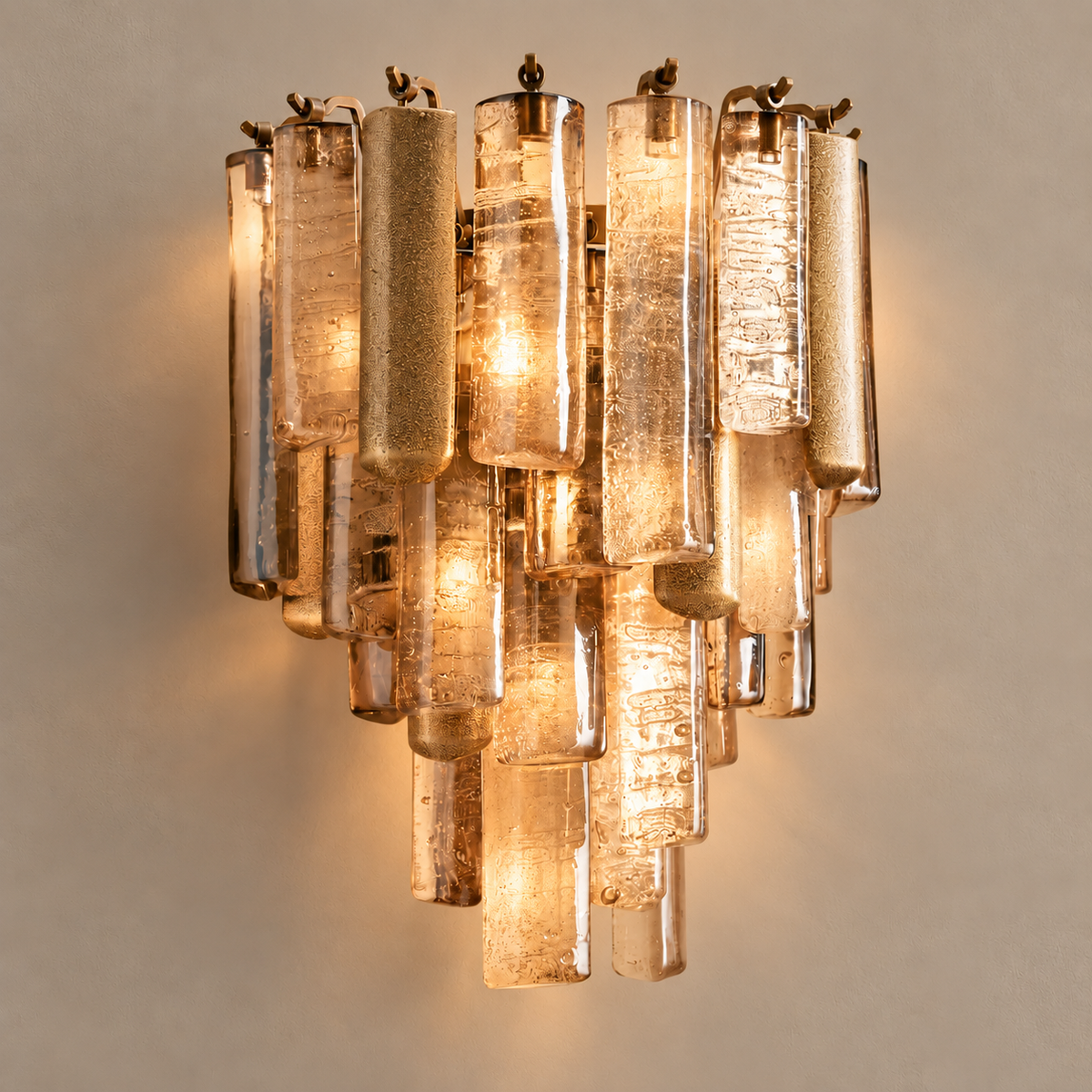 Veneziana cast glass wall sconce, illuminated on a stone-beige wall
