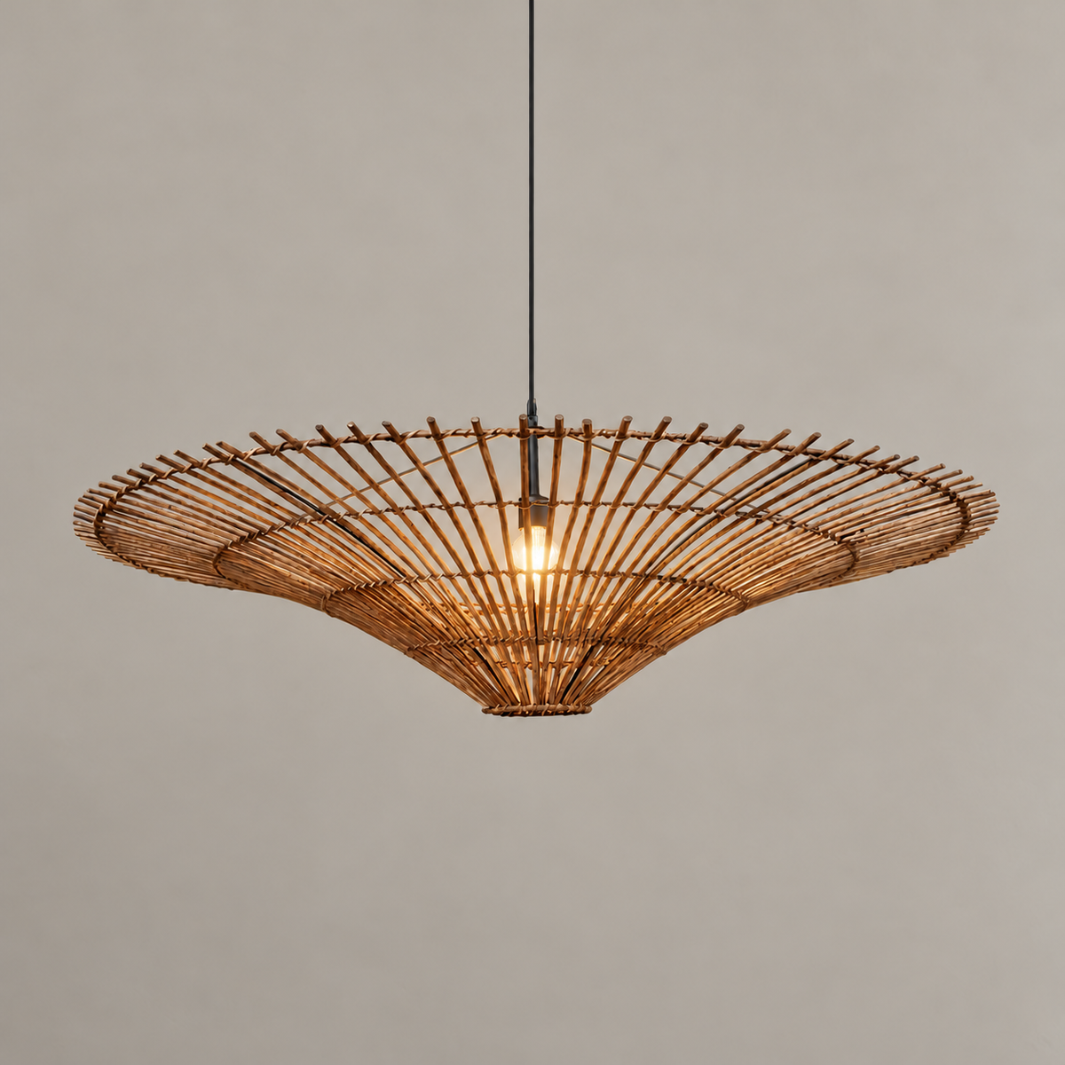 Brown CLWIC wicker pendant with its shallow curved shade, illuminated